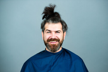 Funny man at the hairdresser getting a haircut. Hipster client in professional hairdressing salon. Professional barber styling hair of his client.