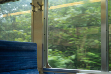 電車の空席と中から見える緑の景色