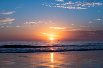 Fototapeta premium Calm sea with sunset sky and sun through the clouds over. Ocean and sky background, seascape.