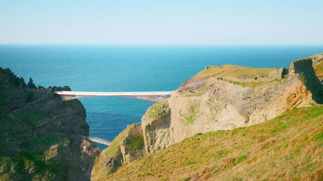 Tintagel Castle bridge, Island in Cornwall, England UK un 4K. Supposed birthplace of King Arthur with a rugged, cliff-top backdrop, on-site cafe and souvenirs, scenic rocky views with bridge steps.
▲