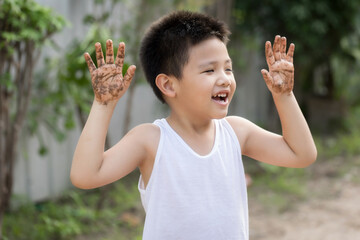 Happy Asian children playing outside with dirty hands