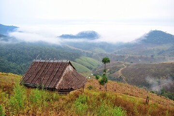 Firewood hut with morning mist from the top of the mountain in Mae Hong Son province, Thailand.
