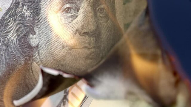 Fire burning up 100 US Dollar bill, economy collapse concept
