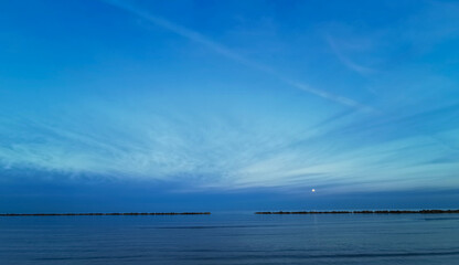 Tramonto sul mare con luna nel cielo
