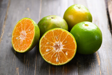 Green tangerine orange fruit on wooden background