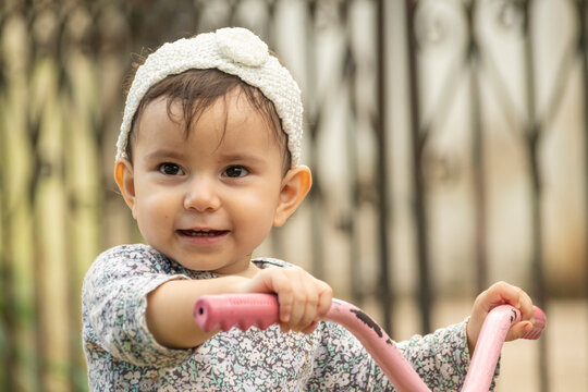 Cute toddler child, boy, playing with tricycle in park and eating apple, kid riding bike on sunset