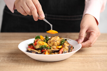 Food stylist decorating Thai food in white dish