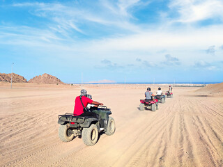 ATV rally. man driving quad bike in Sinai desert. Happy tourist having fun during summer vacation