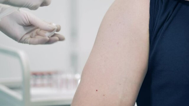 Close up of male arm getting injected with a vaccine