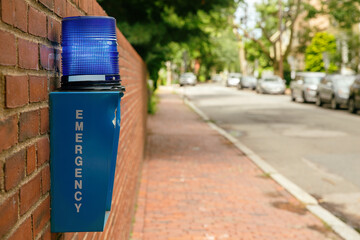 Emergency button outdoor in the city street. Blue box with alarm system and blue warning light on...