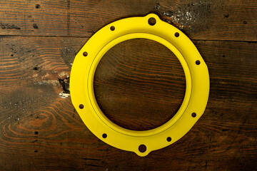 Yellow silicone oil seal, steering knuckle of the front axle of an SUV car on a dark wooden background with nuts, close-up.