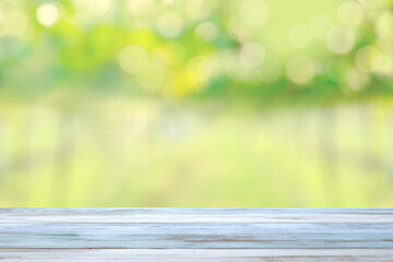 Light blue wooden table with blurred green vineyard, garden background for agricultural or natural...