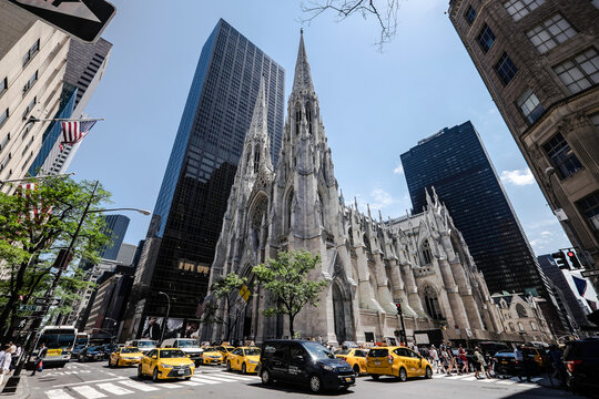 NEW YORK, USA - JUNE 6 2015: Wide angle view of the St. Patrick's Cathedral in New York with yellow NYC cabs on a sunny day
