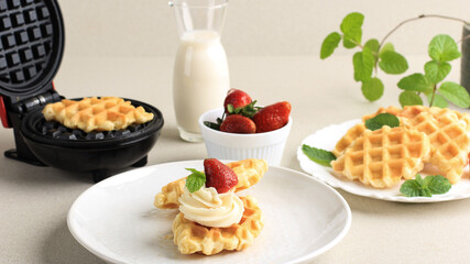 Fresh Baked Delicious Homemade Croissant Waffle with Strawberry. Served on White Plate, Cream Clean Background for Advertising. Served on WHite Plate with Milk, Strawberry, and Mint Leaf