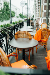 bright outdoor cafe terrace with wicker wooden furniture, orange fruits and green plants for decoration. summer terraces of restaurants. selective focus