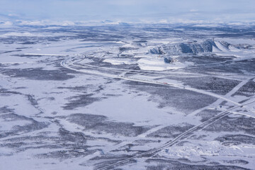 Aerial shot of the Kiruna area with a road in Lapland in Sweden in winter. At the top right the...