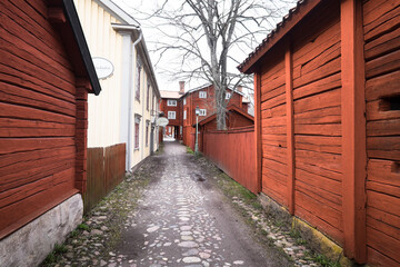 Fototapeta na wymiar LINKÖPING, SWEDEN, MARCH 14, 2020: View of traditional timber houses with deep Falu red or falun red paint in the old town Gamla Linkoping, Sweden
