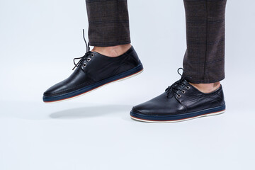 A man is wearing classic black shoes made of natural leather on lace, shoes for men under business...