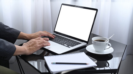 Cropped shot businessman sitting in his room and working with laptop.