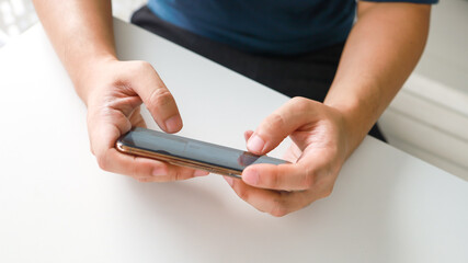 Man playing game on mobile phone. gamer boy playing video games holding Smartphone working mobile devices. cell telephone technology e-commerce concept