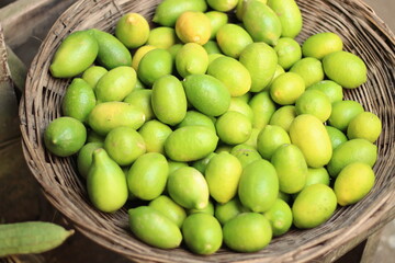 A bunch of lemon at the market in a bamboo cage.
