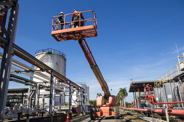 Two male  industry working at high in a boom lift © chitsanupong