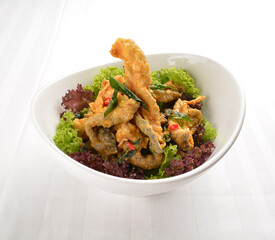 popular deep fried crispy salmon fish skin with salted egg yolk paste sauce in white background asian snack cuisine halal fast food menu