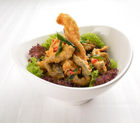 popular deep fried crispy salmon fish skin with salted egg yolk paste sauce in white background asian snack cuisine halal fast food menu