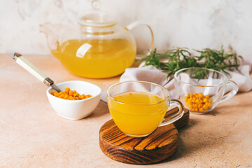 Cup of healthy sea buckthorn tea on table