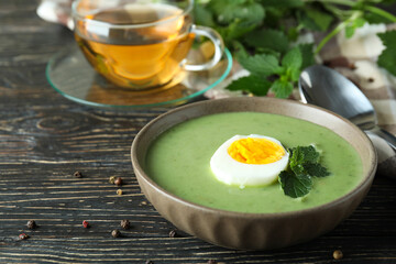 Concept of healthy food with nettle soup on wooden table