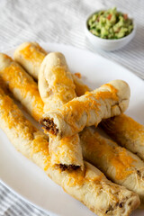 Homemade Cheesy Taco Breadsticks with Guacamole, side view.