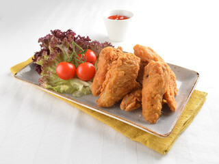 deep fried crispy golden chicken wings with tomato green salad in white background western snack cuisine halal fast food menu