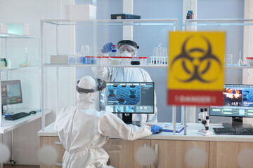 Medical staff wearing ppe suit in laboratory danger zone during pandemic. Group of doctors...
