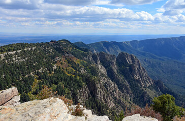 Fototapeta na wymiar looking out at the sandia peak tramway terminus, forest,and granite peaks on a fall day from sandia peak, new mexico