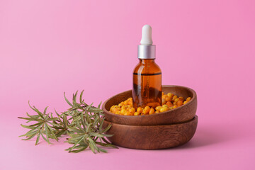 Bottle of healthy sea buckthorn oil on color background