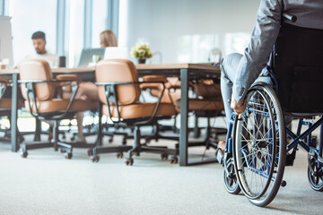 Fototapeta na wymiar Close up. Disabled Man on Wheelchair in Office. Disabled Young Man. Man on Wheelchair. Recovery and Healthcare Concepts. Teamwork in Office. Young Workers. Sitting Man. Happy Worker.