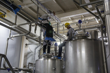 Male work the process of cream cosmetic fermentation at the manufacturing stainless tank