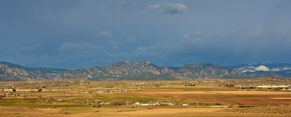 dramatic early morning lighting over rock creek farm and the front range of the colorado rocky mountains as sen form broomfield, colorado © Nina
