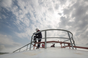 Female worker inspection roof storage tank