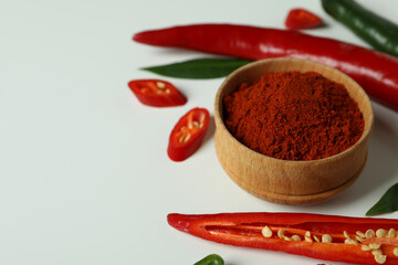 Red and green peppers and powder on white background