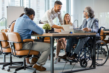 Group of business people in a meeting with colleague in a wheelchair for inclusion. Young...