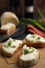 Fototapeta na wymiar Bread with cream cheese and green onion on table, closeup