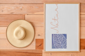 Stylish hat and picture hanging on wooden wall