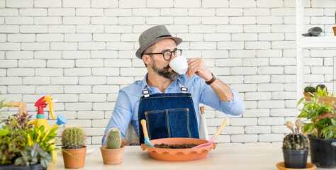 An elderly man wearing glasses is happy with tree care and decoration. It is a hobby of home gardening, living happily after retirement