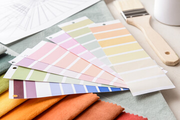 Composition with paint color palettes and fabric samples on light background