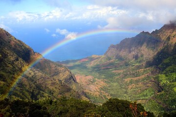 stunning  rainbow over the kalalau valley, as seen from the pu'u o kila  overlook in  kauai, hawaii   