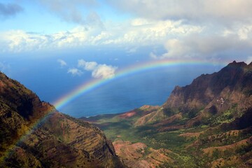 colorful rainbow over kalalau valley 
 and the pacific ocean in kauai, hawaii      
