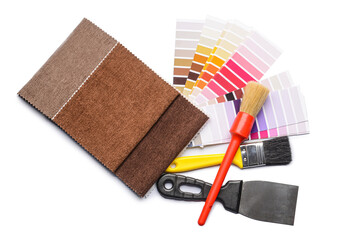 Paint color palettes with fabric samples and tools on white background