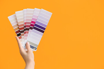 Female hand and paint color palettes on color background