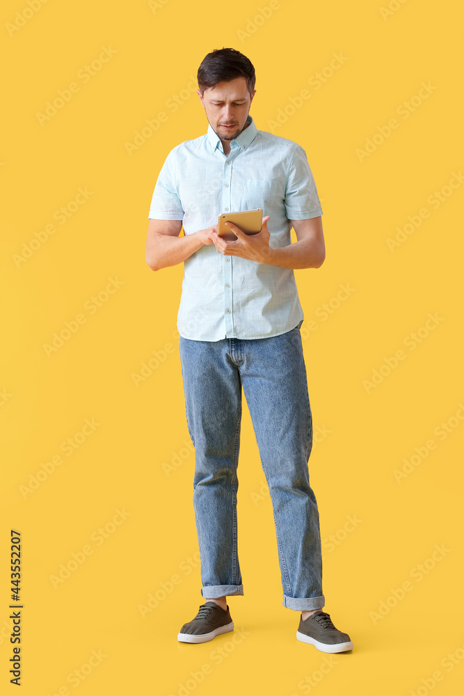 Poster handsome man using tablet computer on color background